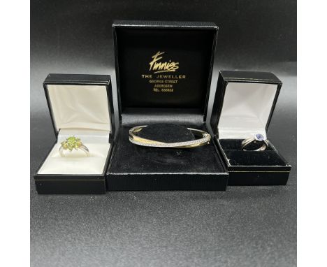 Mixed lot of silver,
silver and gold plated heavy bangle with stones,
tanzanite ring and a peridot ring