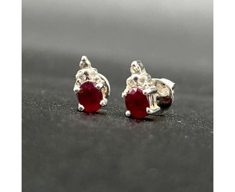 18ct white gold ruby and diamond earrings,
oval cut ruby,
5mm x 3mm ruby stone,
set with 3 diamonds each earring,
excellent c