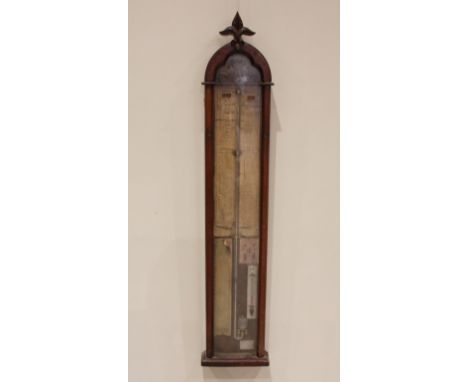 A Victorian Gothic influence walnut cased Admiral Fitzroy barometer, late 19th century, the case surmounted with a carved lea