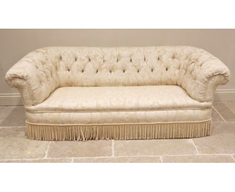 A Victorian country house button back Chesterfield sofa, upholstered in foliate damask fabric, of typical deep set form with 