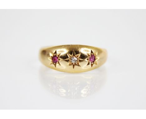 An Edwardian diamond, ruby and 18ct gold ring, comprising a central mixed cut diamond flanked by two mixed cut rubies, all in