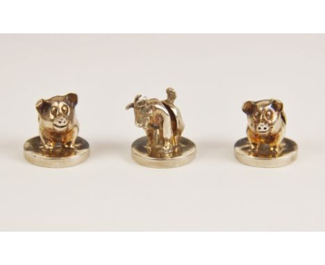 A pair of novelty silver menu-card holders, Boodle &amp; Dunthorne, London 1992, modelled as pigs upon a circular base, each 