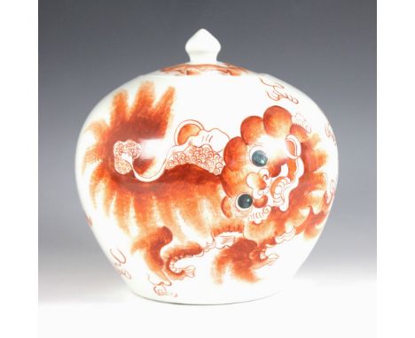 A Chinese porcelain rouge de fer jar and cover, 20th century, the compressed globular jar decorated to the exterior with dogs