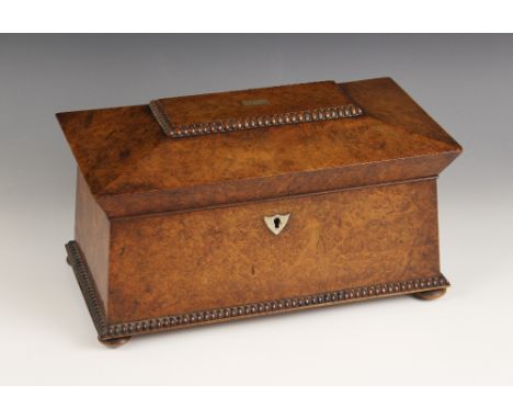 A burr walnut and rosewood sarcophagus shaped tea caddy, early 19th century, the hinged cover inlaid with a central mother of