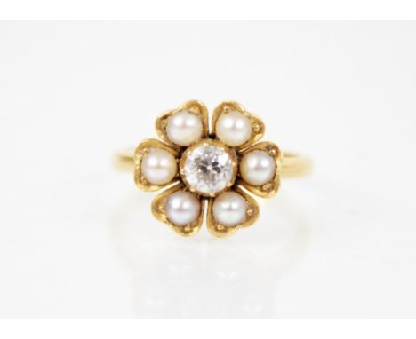 A Victorian pearl and diamond floral ring, comprising a central old cut diamond weighing approximately 0.25 carats (4.1mm W x