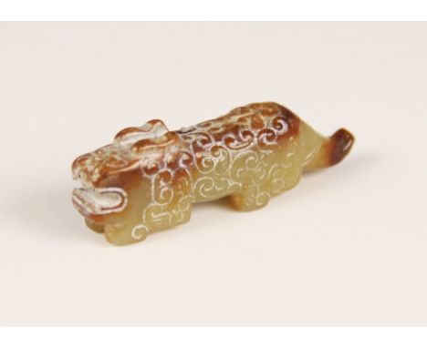 A Chinese carved jade mythical beast, in the Archaic style, with green and mutton fat coloured stone, the body of the beast c