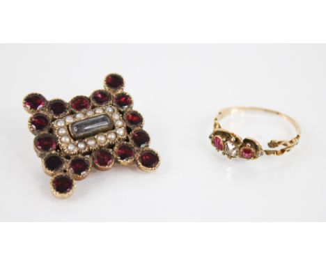 A Victorian diamond and ruby ring, designed as a central cushion cut diamond, flanked by two mixed cut rubies with a further 