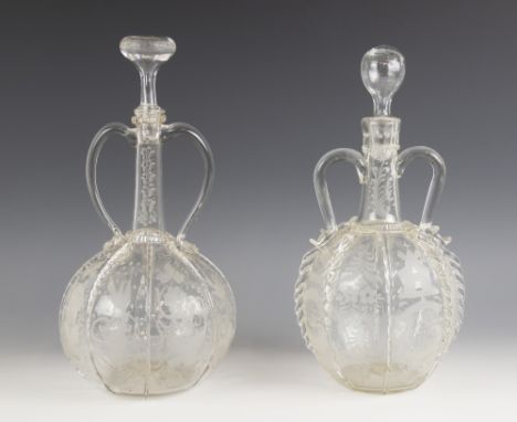 Two Dutch globe and shaft decanters, each with twin handles, the globes sectioned with prunted and trailed ribs interspersed 