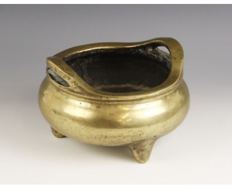 A large and substantial Chinese bronze censer, 19th century, of compressed circular form with plain polished exterior, two ha