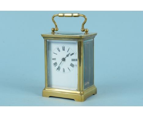 A late 19th Century brass carriage clock with enamel dial and bevelled glass throughout
