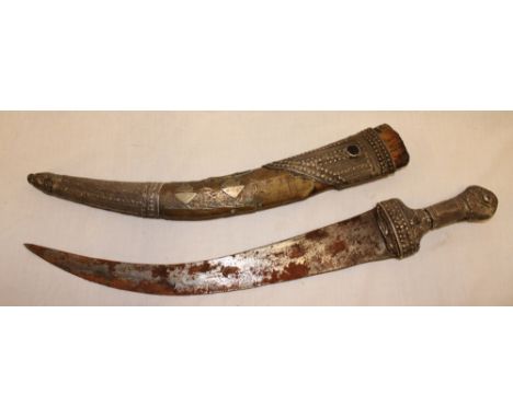 An old Middle Eastern dagger with 13" curved blade and silvered hilt in decorated scabbard (af)