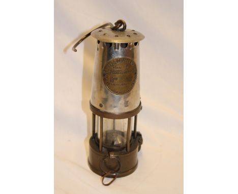 A brass and steel miners lamp by The Protector Lamp and Lighting Co. 