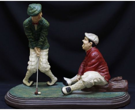 A painted plaster figure group, of Stan Laurel and Oliver Hardy playing golf, on plinth base, 48 x 62cm.