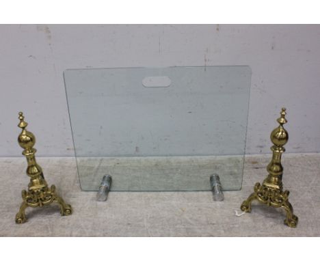 A modern glass firescreen, of plain rectangular form, on polished and brushed stainless steel bearers, together with a pair o
