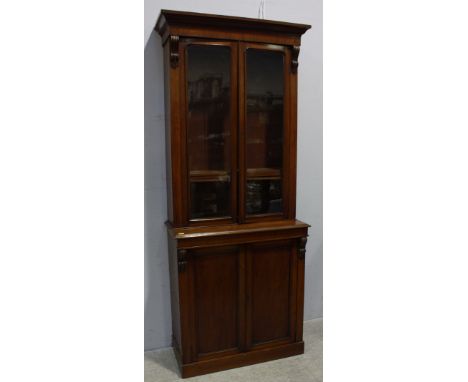 An Edwardian stained walnut bookcase, with ogee moulded cornice above a plain frieze and pair of glazed doors enclosing adjus