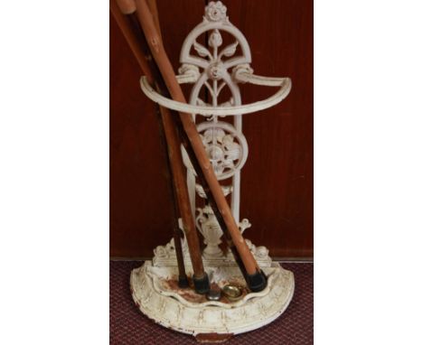 A Victorian cast iron and white painted umbrella and stick stand, and five walking sticks.