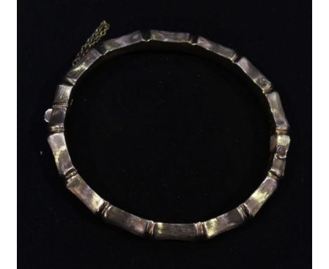 A 9ct gold hinged bangle, cast as bamboo, with push-clip and safety chain, approximately 13.8 grams