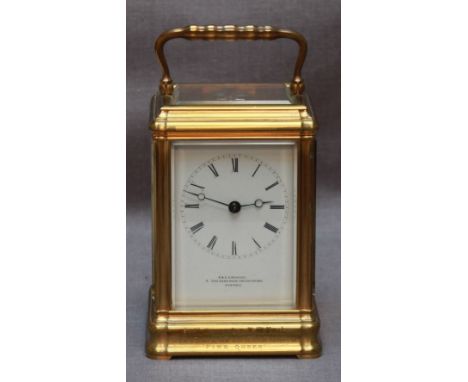 A 19th century brass carriage clock, with eight-day movement striking a bell, White enamel dial with Roman numerals, retailer