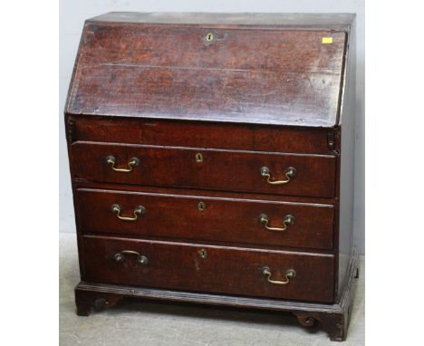 A George III oak bureau, fall-front enclosing secret compartments, drawers and pigeonholes, recessed well enclosing more secr