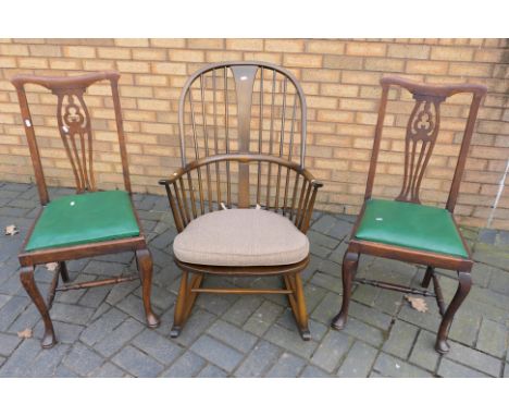Ercol - An Ercol Chairmakers Windsor rocking chair (gold label) and two dining chairs. [3]