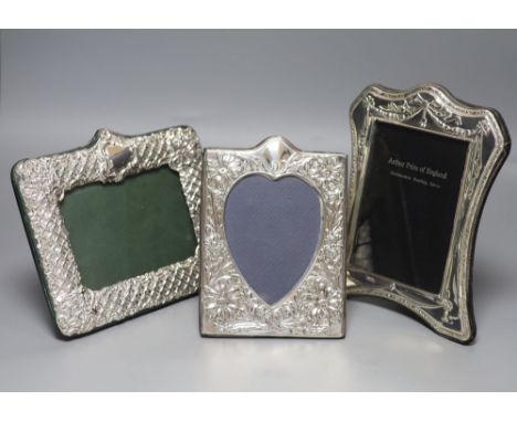 Three modern shaped and embossed silver easel photograph frames, one rectangular with heart-shaped plate, embossed with flowe