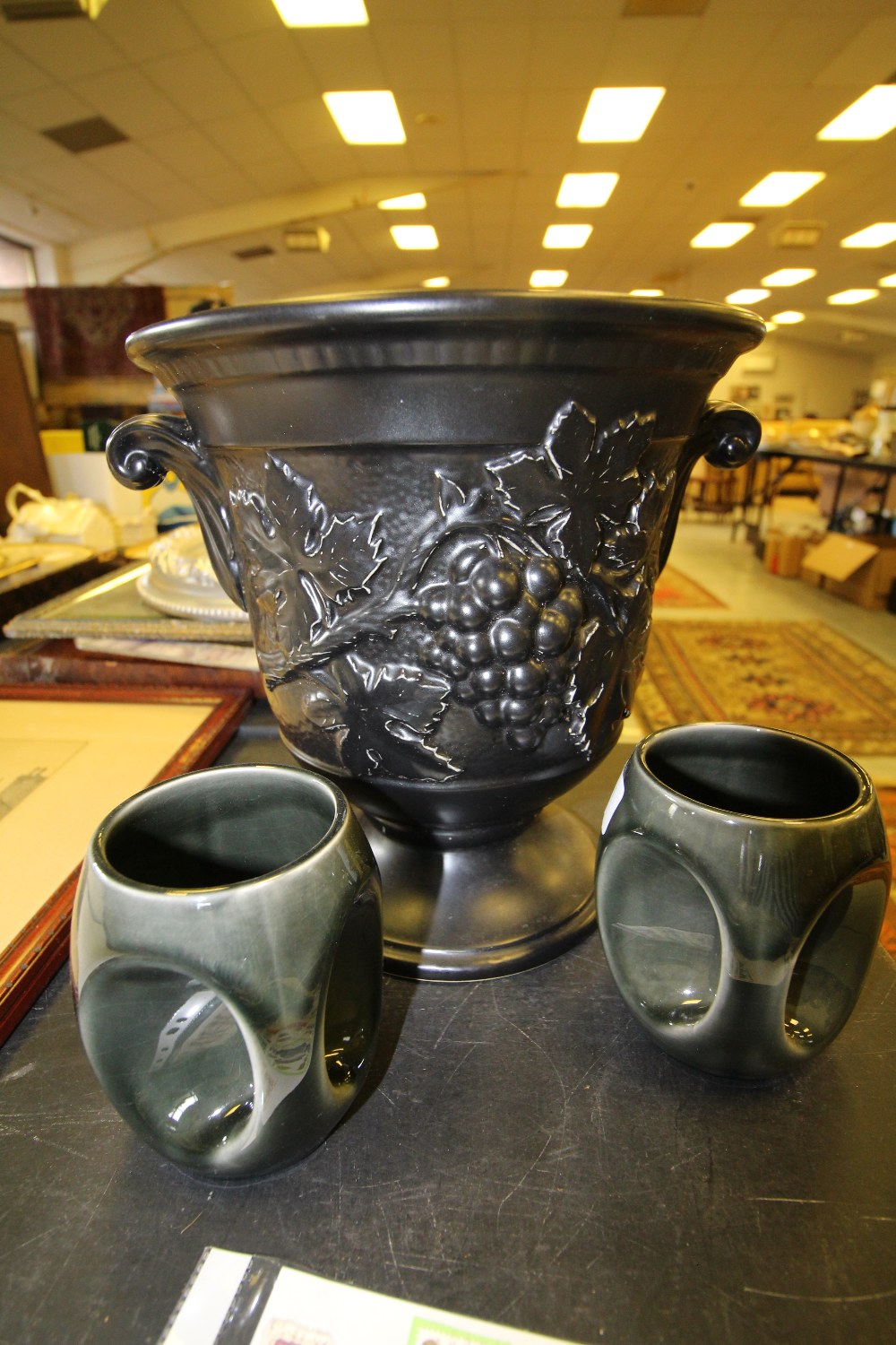Holkham pottery, large classical black urn style vase and two owl eye mugs
