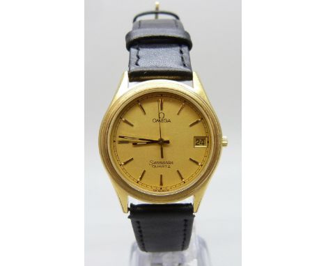 A gold plated Omega Seamaster wristwatch with date aperture, champagne dial, quartz movement, on a black leather strap, 35mm 