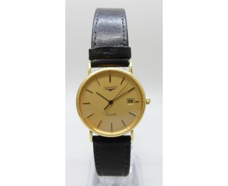 An 18ct yellow gold Longines wristwatch with date aperture, champagne dial, quartz movement on a black leather strap, 34mm in