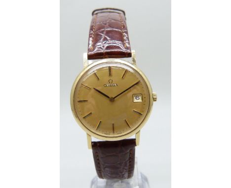 A 9ct yellow gold Omega wristwatch with date aperture, champagne dial, manual wind movement, on a burgundy leather strap, 34m