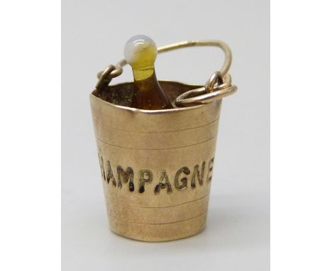 A 9ct gold charm in the form of a champagne bucket, with glass bottle inside, 1.5g