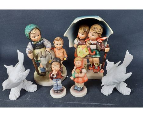 A collection of GOEBEL figurines to include a 1975 Leading the goat (334) 14x10cm, Young boy and girl sheltering under a umbr