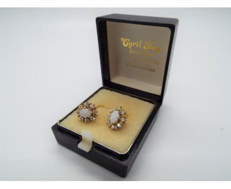 A pair of 9ct gold and white opal earrings, approximately 2.69 grams all in.