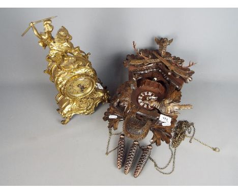 A cuckoo clock with carved decoration  and three 'pinecone' weights and a brass cased mantel clock (A/F) with quartz movement