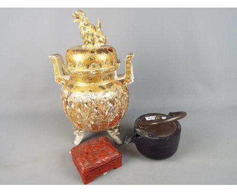 A large Meiji period Satsuma koro and cover of oviform with twin pierced handles and raised on tripod mask and tongue support