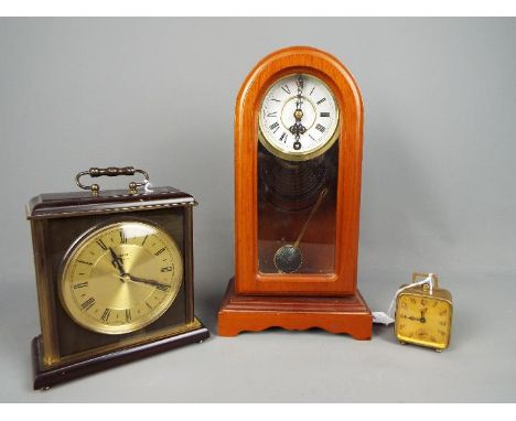 Three clocks to include a Brevete travel alarm clock, a Metamec mantel clock and similar. [3];