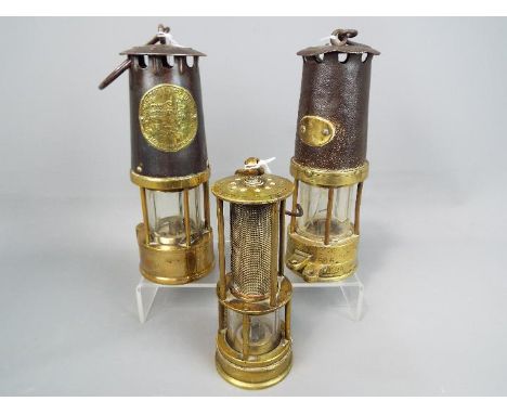 Three safety lamps to include one marked Protector Lamp &amp; Lighting Co, Eccles Manchester, largest approximately 25 cm (h)