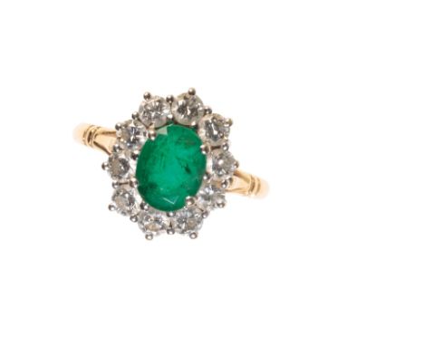 AN EMERALD DIAMOND CLUSTER RING the oval-cut emerald, surrounded by a border of ten brilliant-cut diamonds approx 1ct total w