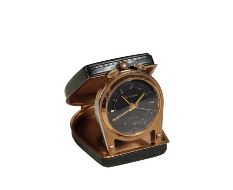 AL-FARDAN: A MINIATURE BRASS PURSE ALARM CLOCK with manual key wind movement, the black dial with gold baton numerals and gol