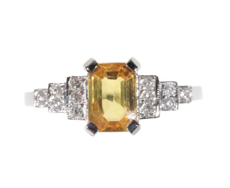 AN ART DECO STYLE  YELLOW SAPPHIRE AND DIAMOND RING the claw-set sapphire, flanked either side with stepped rows of diamonds,