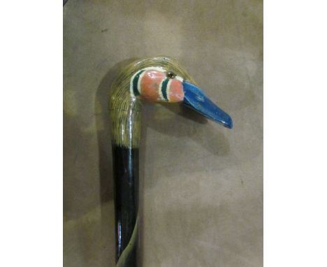 A hand-painted walking stick the handle in the form of a duck, cracking to paint on the neck, 85cm long