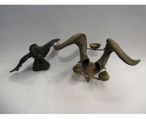 A metal vulture with a repaired wing and an inkwell with two ram's horns