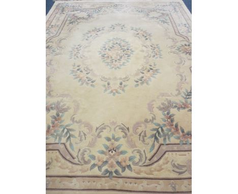 LARGE WASHED WOOLLEN CARPET - all-over floral pattern on a central cream ground with pink borders and tasselled ends, 370 x 2