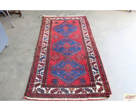 An approx 6'9" x 3'5" red patterned carpet 