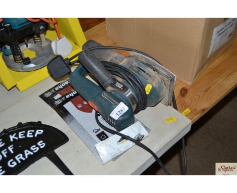 A Black &amp; Decker orbital sander and extra sanding pads