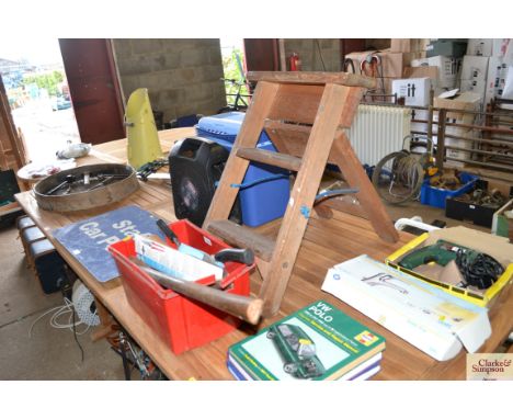 A wooden step stool and a box containing tools