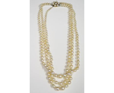 A 21" Three Strand Pearl Necklace with a large 9ct gold pearl set clasp (20mm diam.) 