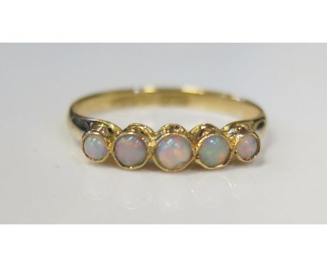 An 18ct Yellow Gold and White Opal Millegrain Set Five Stone Ring, size M.5, 2g 