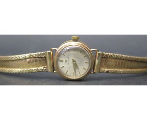 A Ladies OMEGA 9ct Gold Wristwatch with17 jewel manual wind movement no. 18547040 and with integral bracelet. Sold with paper