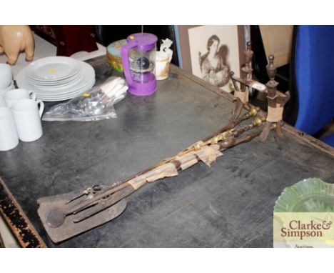 A pair of steel fire dogs; three fire irons and a brass toasting fork