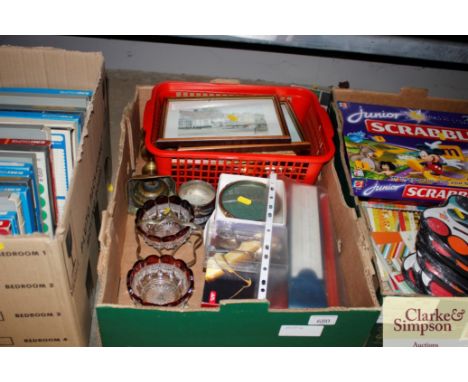 A box containing various prints, brass candlestick, preserve stand, spoons etc